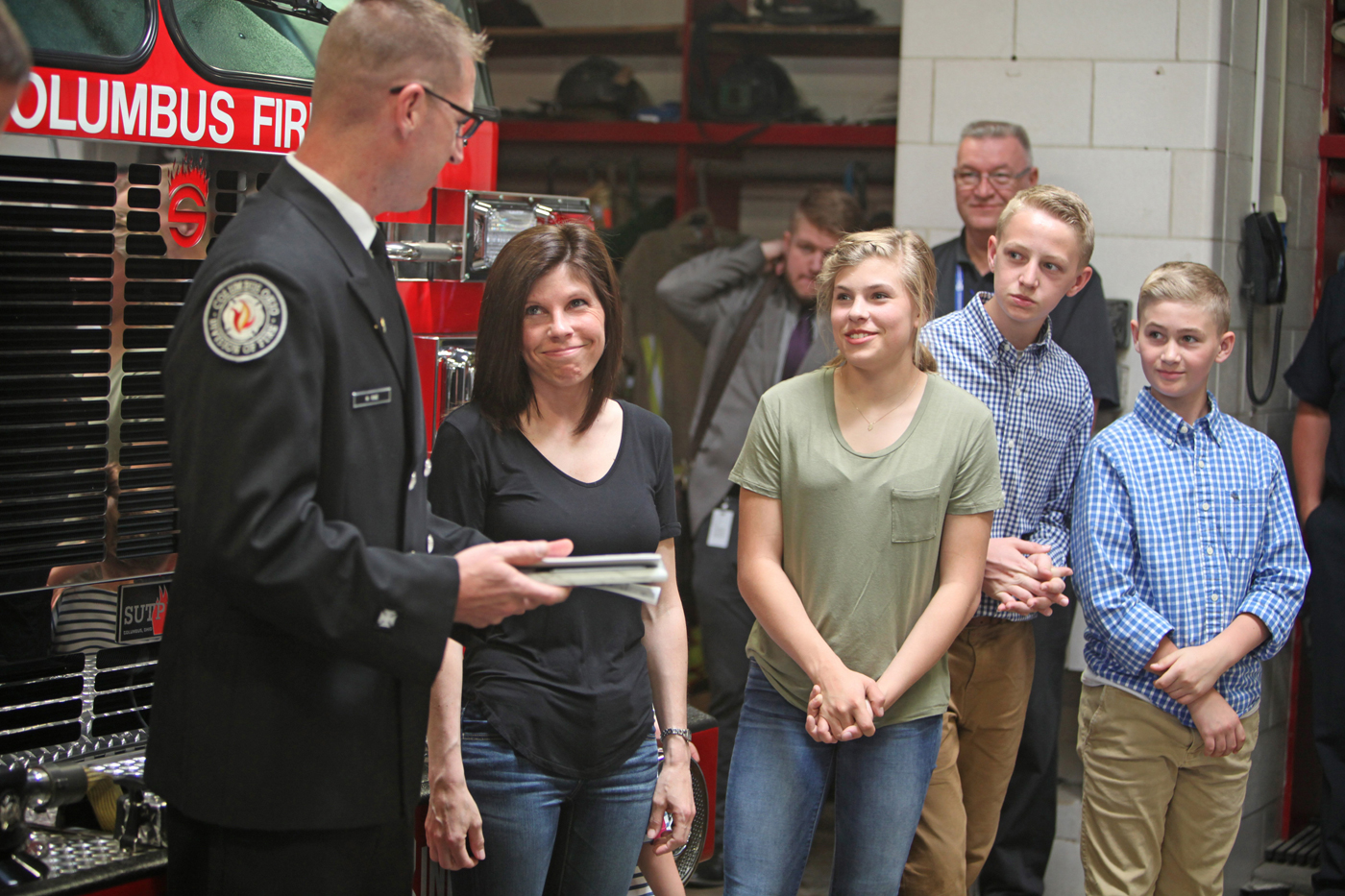 Mark Rine looks at his family after a proclamation was read in his honor as he was named Firefighter of the Month.