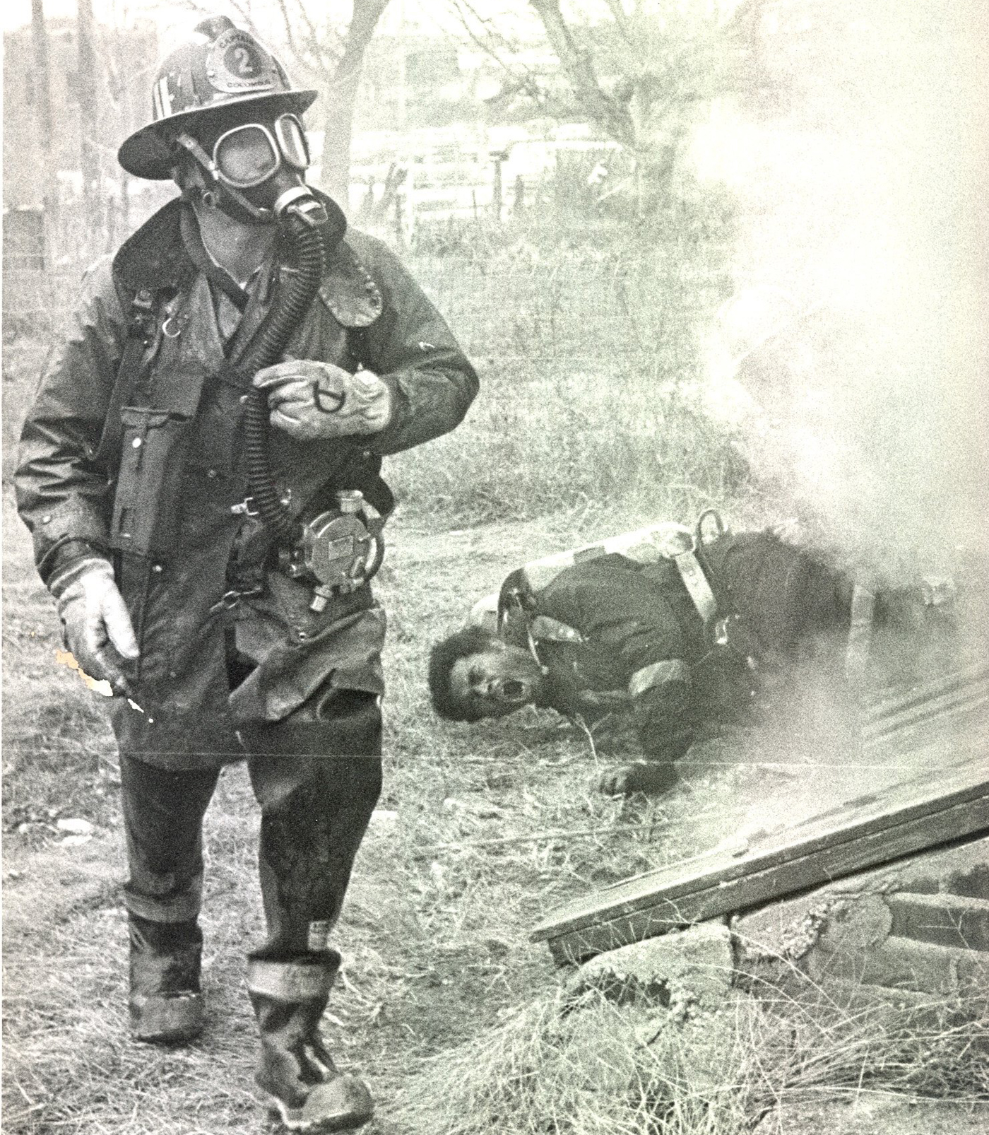 1975: Fire division trainee Stephen Ayers lies on the ground gasping for air after jumping from a first-floor window at a training fire. A firefighter runs to summon help. Ayers was treated for smoke inhalation at Grant Hospital. His face mask came off inside the burning vacant building. | Dispatch file photo
